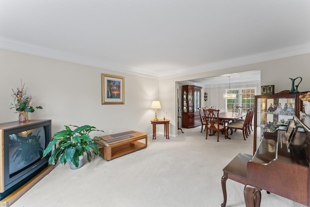 carpeted living room featuring ornamental molding and an inviting chandelier