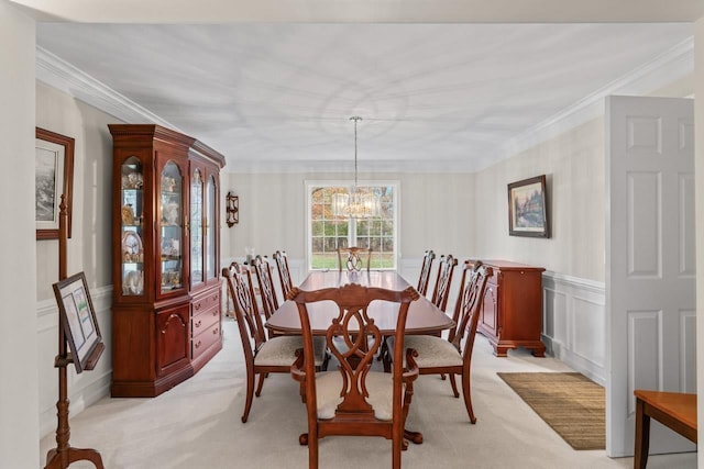 dining area featuring crown molding, light colored carpet, and a chandelier