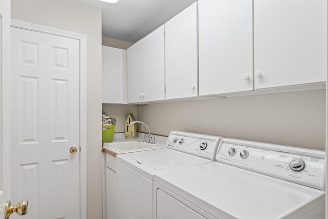 laundry room with cabinets, washing machine and clothes dryer, and sink