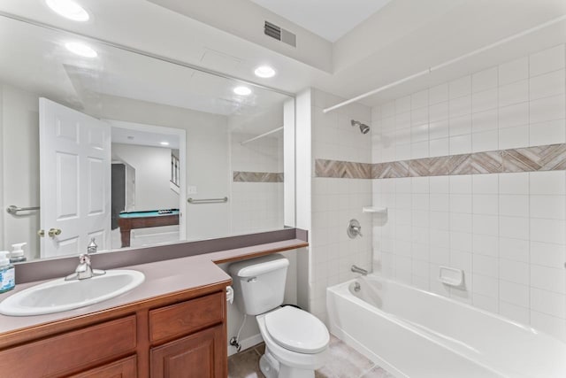 full bathroom featuring tiled shower / bath, vanity, and toilet