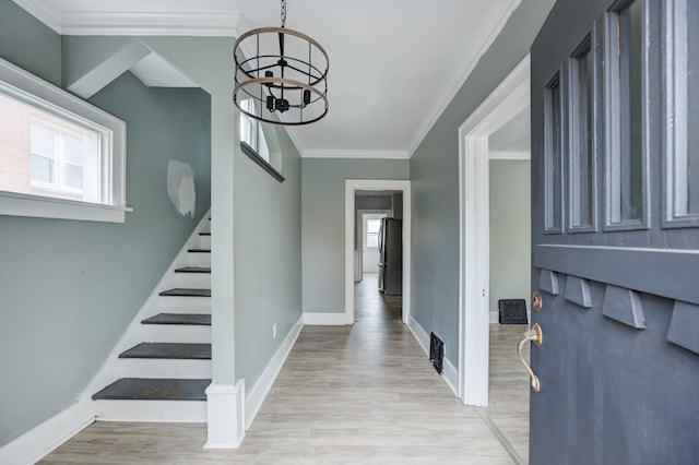 entryway featuring light hardwood / wood-style flooring, an inviting chandelier, and crown molding