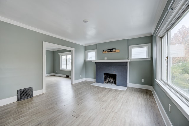 unfurnished living room featuring a fireplace, light wood-type flooring, and crown molding