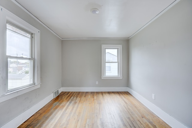 unfurnished room featuring light wood-type flooring and ornamental molding