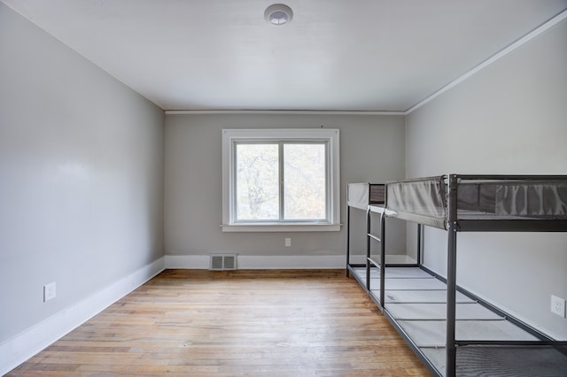 unfurnished bedroom with crown molding and light hardwood / wood-style flooring