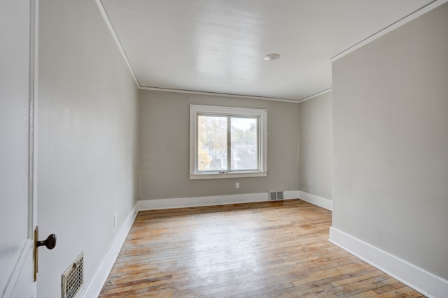 spare room with light hardwood / wood-style flooring and crown molding