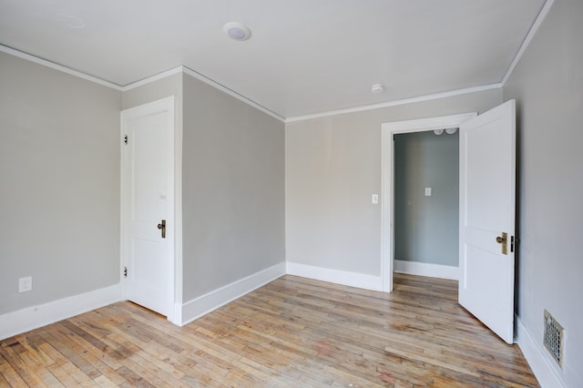 spare room featuring light hardwood / wood-style floors and ornamental molding