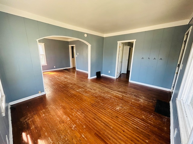 unfurnished room with ornamental molding and dark wood-type flooring