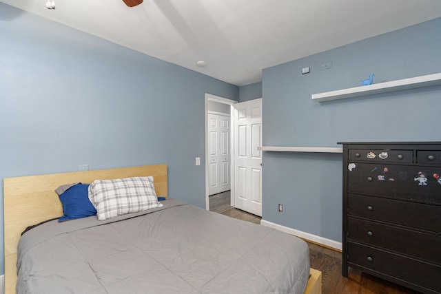 bedroom with dark hardwood / wood-style floors and ceiling fan