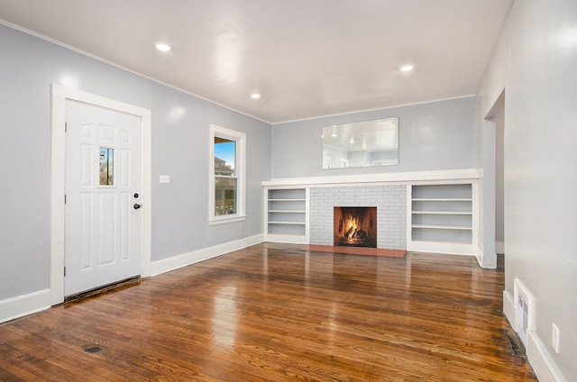 unfurnished living room with a brick fireplace, visible vents, wood finished floors, and recessed lighting