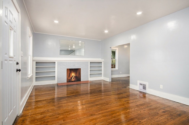 unfurnished living room featuring a fireplace and dark hardwood / wood-style floors