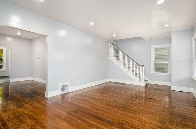 unfurnished room with baseboards, stairway, wood-type flooring, and recessed lighting