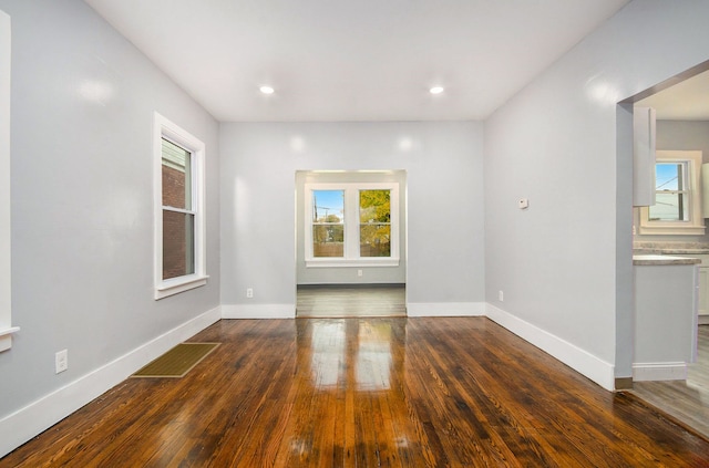 unfurnished room featuring dark hardwood / wood-style floors and a healthy amount of sunlight