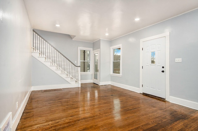 foyer featuring stairway, baseboards, visible vents, and wood finished floors