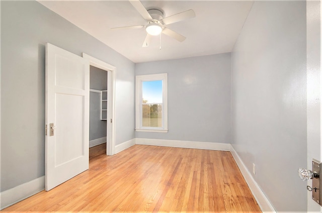 unfurnished bedroom featuring light wood-type flooring, a closet, ceiling fan, and baseboards