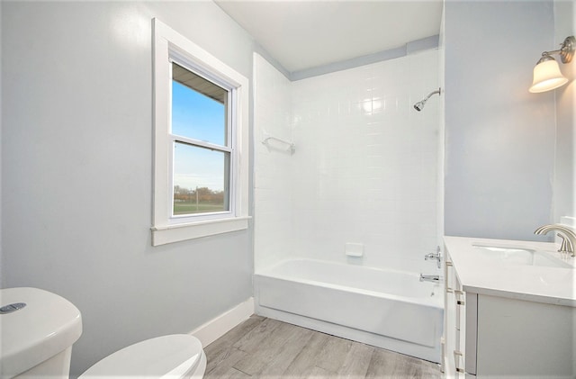 bathroom featuring shower / bath combination, toilet, vanity, wood finished floors, and baseboards