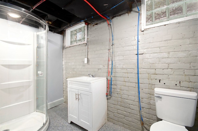 bathroom featuring toilet, brick wall, a stall shower, and vanity