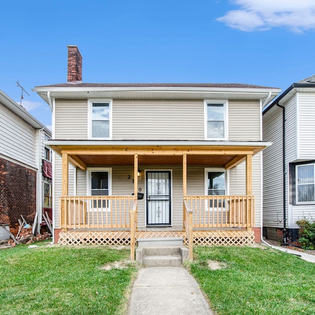 view of front of house with a chimney, a front lawn, and a porch