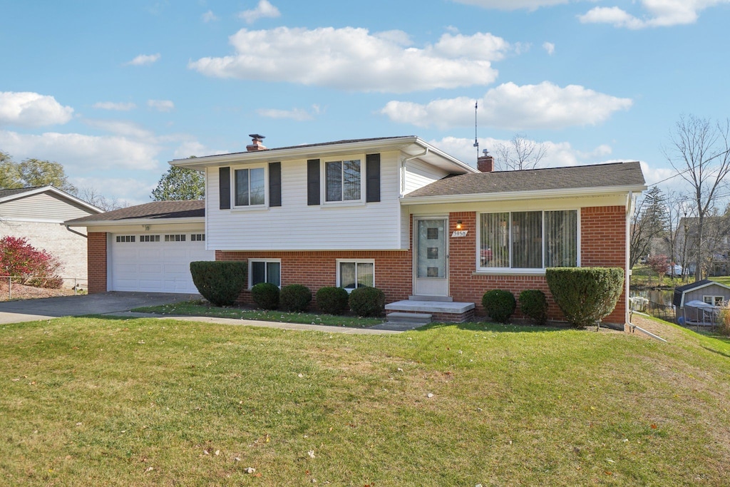 split level home with a front yard and a garage