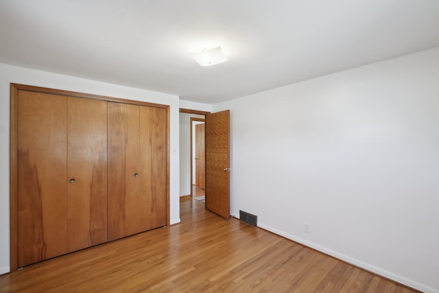 unfurnished bedroom with a closet and light hardwood / wood-style flooring