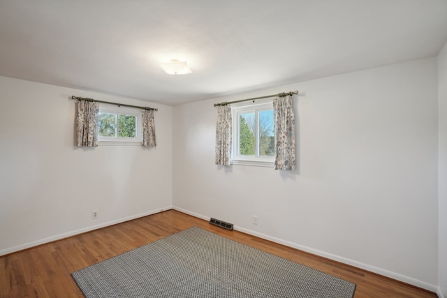 empty room featuring hardwood / wood-style floors and a healthy amount of sunlight