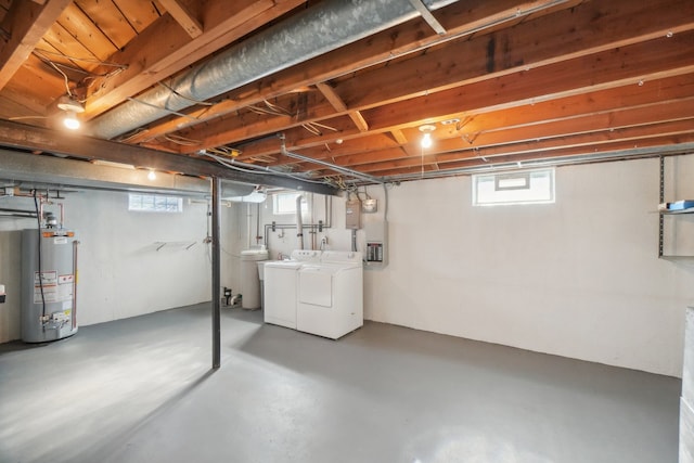 basement with washer and clothes dryer, a healthy amount of sunlight, and gas water heater