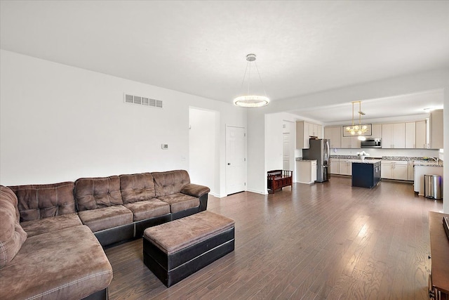 living room featuring dark hardwood / wood-style floors and a chandelier