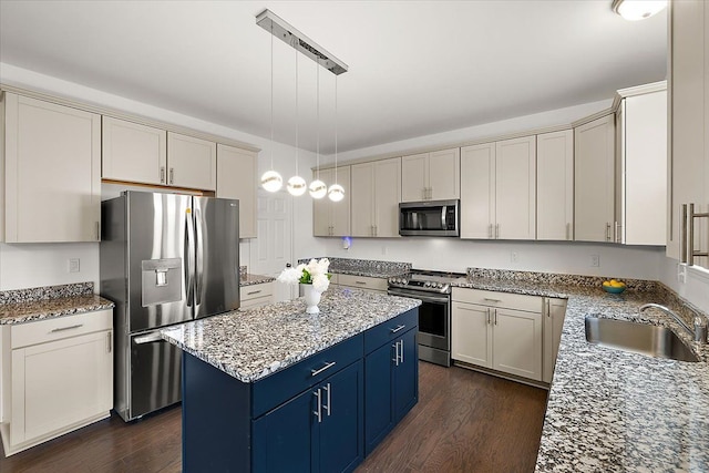 kitchen with sink, a center island, dark hardwood / wood-style floors, decorative light fixtures, and appliances with stainless steel finishes