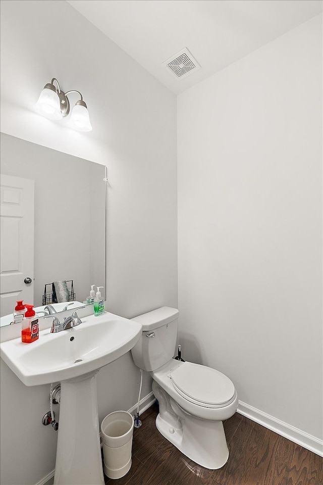 bathroom featuring hardwood / wood-style flooring, toilet, and sink