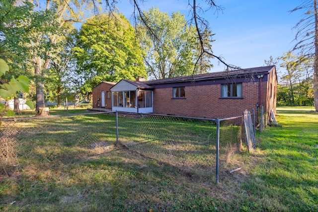 back of house with a sunroom and a lawn