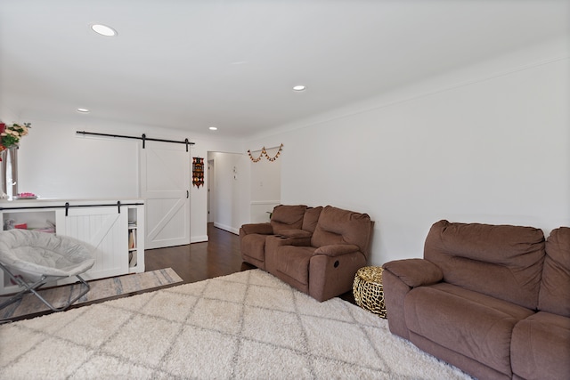 living room with a barn door and hardwood / wood-style floors