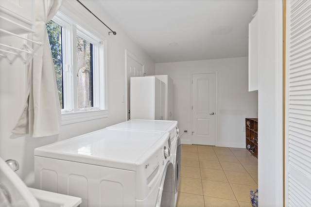 laundry area featuring light tile patterned floors and separate washer and dryer