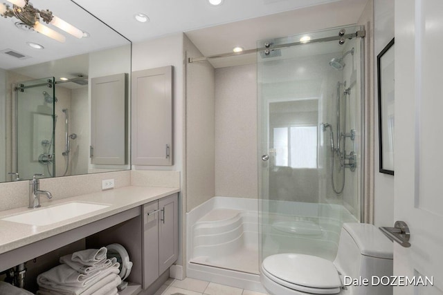 bathroom featuring tile patterned flooring, vanity, toilet, and an enclosed shower