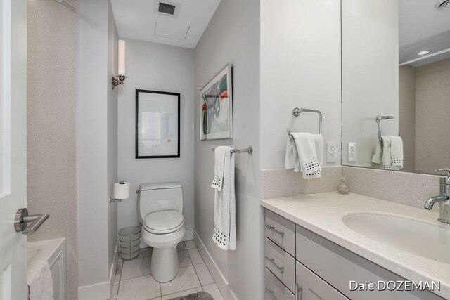 bathroom featuring tile patterned floors, a bathtub, vanity, and toilet