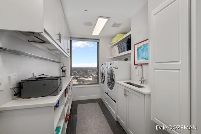 washroom featuring sink, dark tile patterned floors, cabinets, and independent washer and dryer