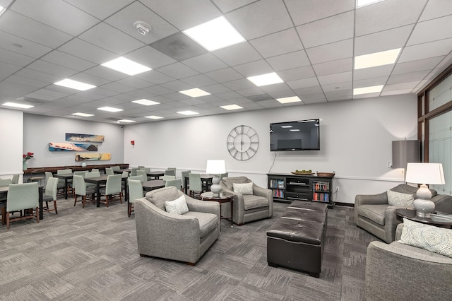 carpeted living room with a drop ceiling