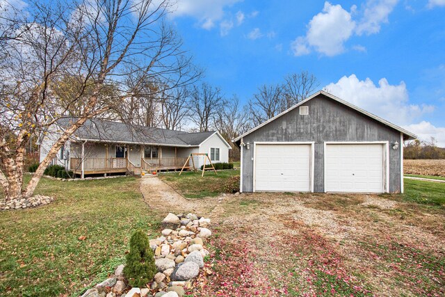 single story home featuring a front yard and a detached garage