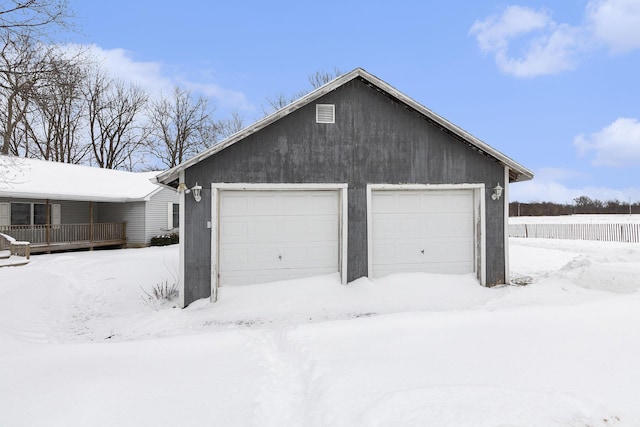 snow covered garage with a garage