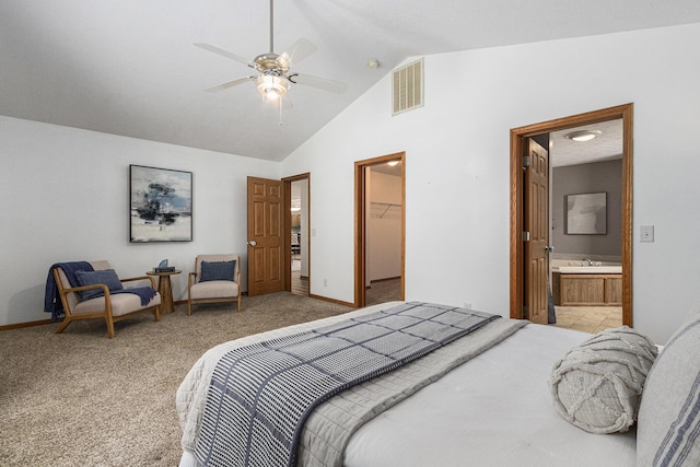 bedroom featuring lofted ceiling, light colored carpet, visible vents, a spacious closet, and ensuite bath