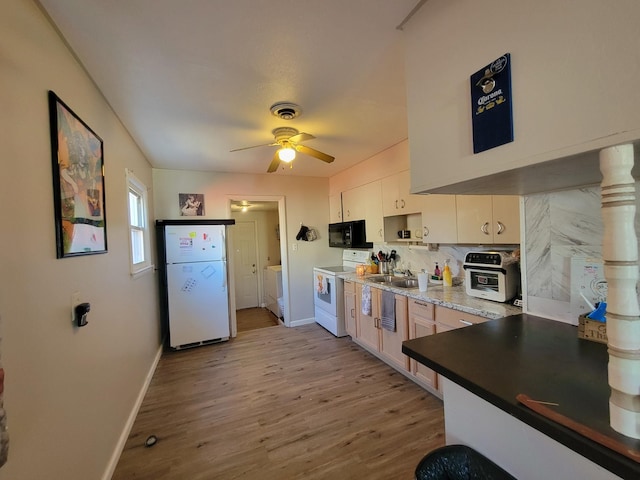 kitchen with washing machine and clothes dryer, ceiling fan, light hardwood / wood-style floors, white appliances, and white cabinets