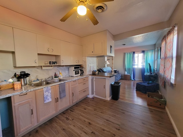 kitchen featuring sink, hardwood / wood-style flooring, ceiling fan, tasteful backsplash, and kitchen peninsula