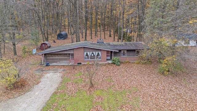 288 E 88th St, Newaygo, MI 49337 - view of front of property with a chimney, brick siding, and a wooded view