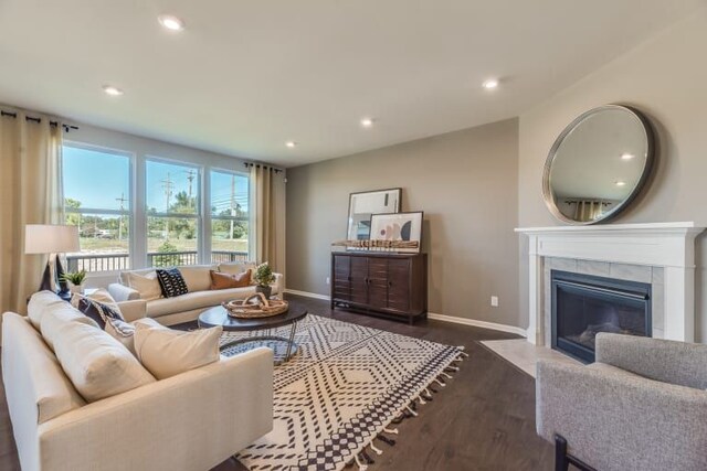 living room with dark wood-type flooring and a tile fireplace