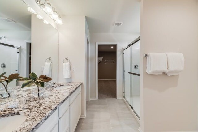 bathroom featuring vanity, tile patterned floors, and walk in shower