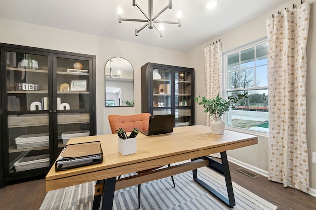 office area with dark hardwood / wood-style floors and a notable chandelier