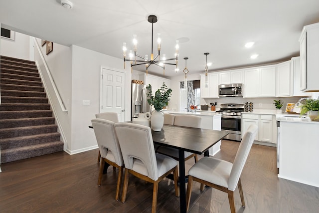 dining area featuring sink, a notable chandelier, and dark hardwood / wood-style flooring