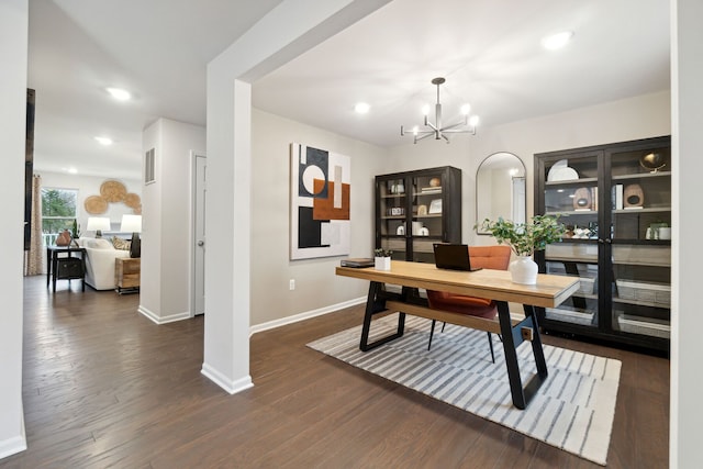 home office with dark hardwood / wood-style flooring and a chandelier