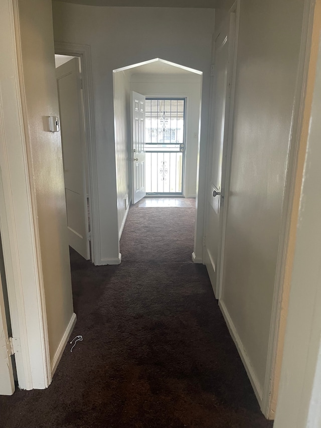 hallway with dark colored carpet