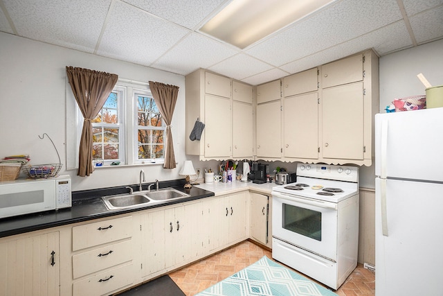 kitchen featuring a drop ceiling, white appliances, sink, and light parquet floors