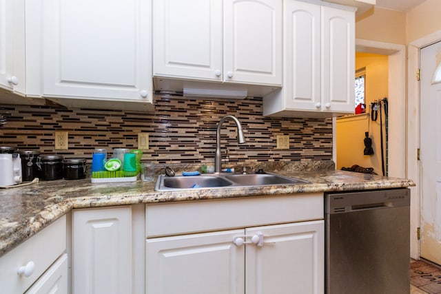 kitchen with stainless steel dishwasher, white cabinets, sink, and tasteful backsplash