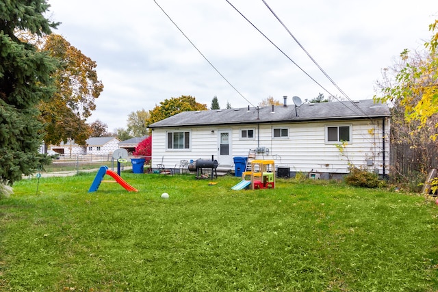 rear view of house featuring a yard